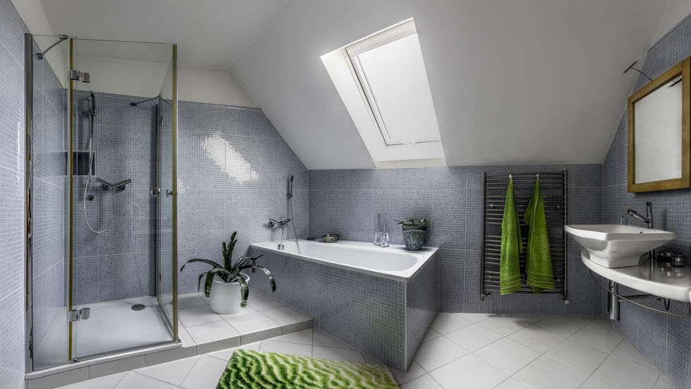 Blick in ein modernes Badezimmer mit grauen Mosaikfliesen
